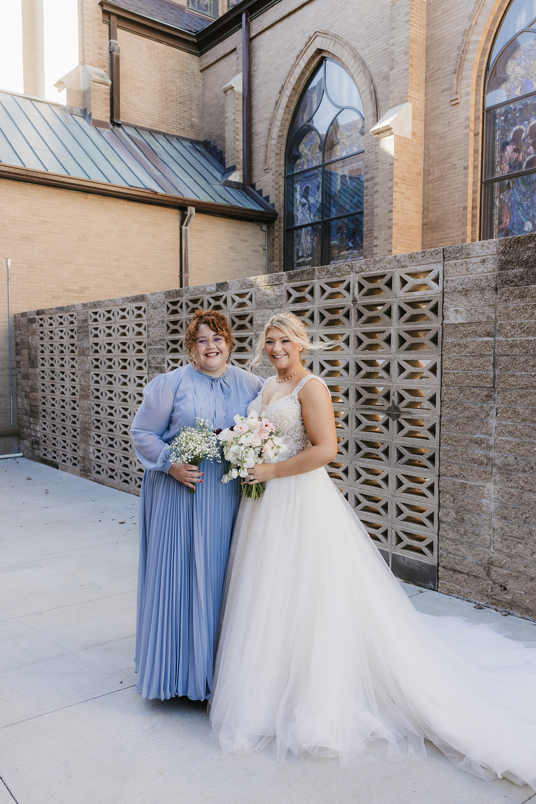 bride and groom take wedding party portraits outside the cathedral