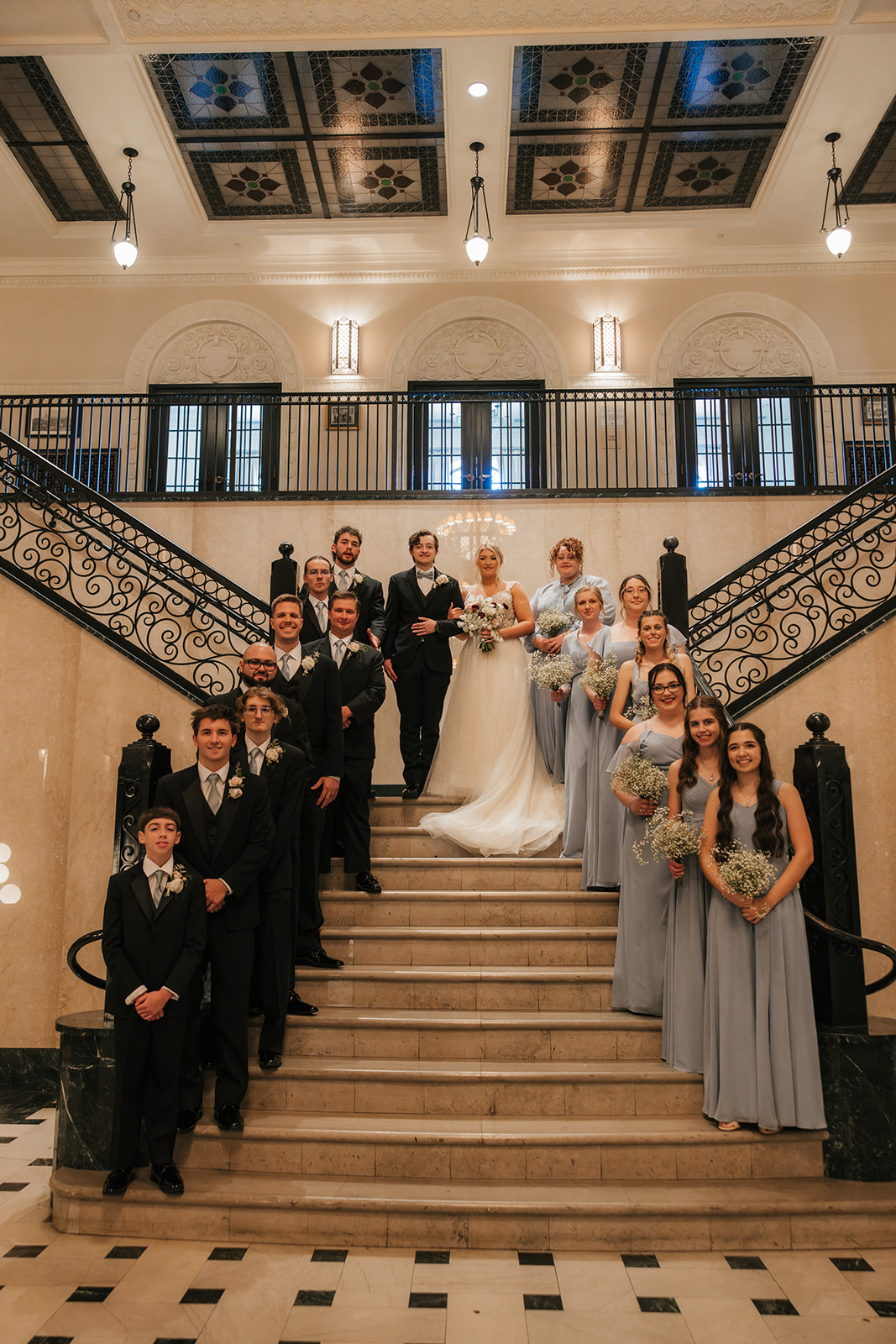 bride and groom take wedding party portraits outside the cathedral