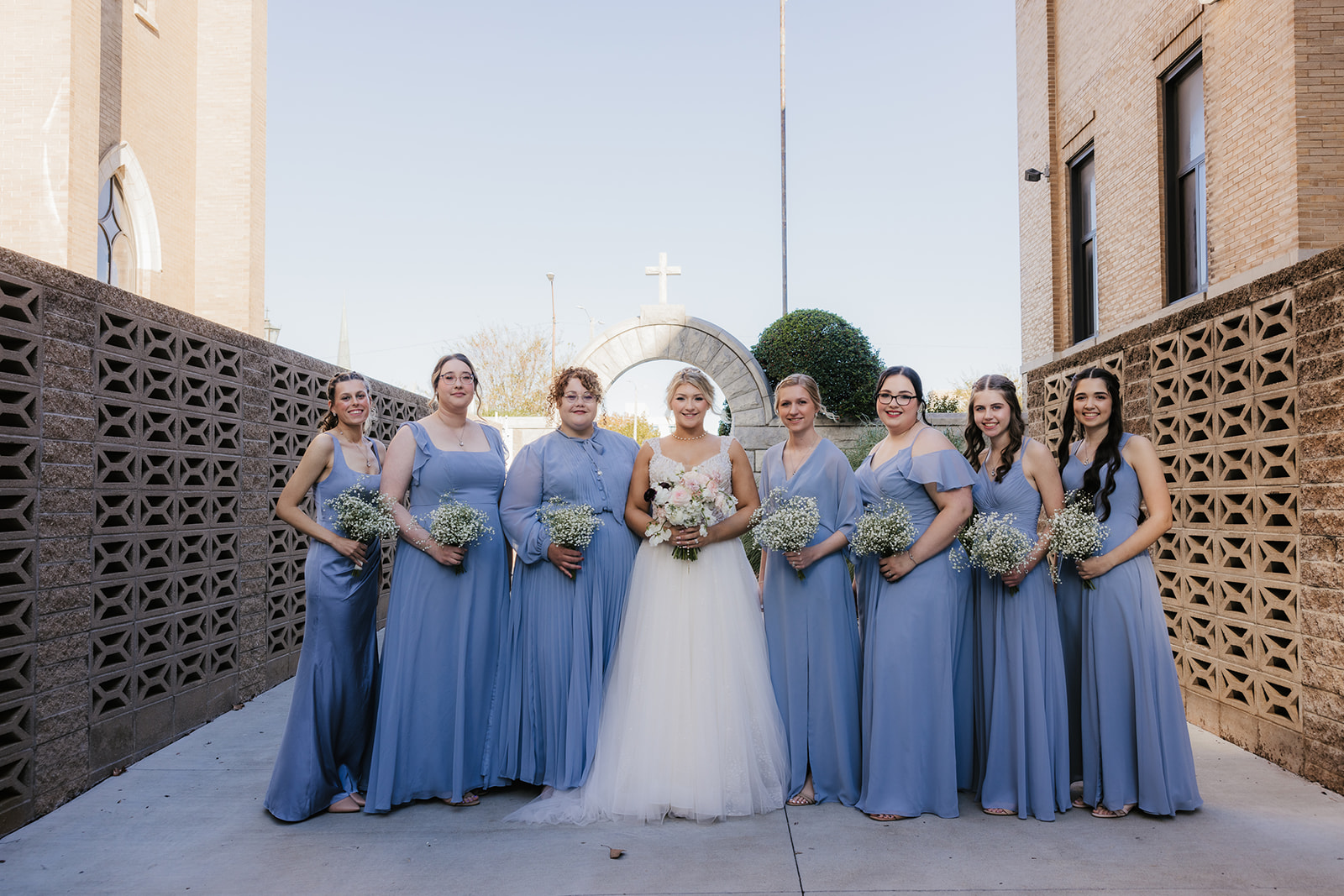 bride and groom take wedding party portraits outside the cathedral