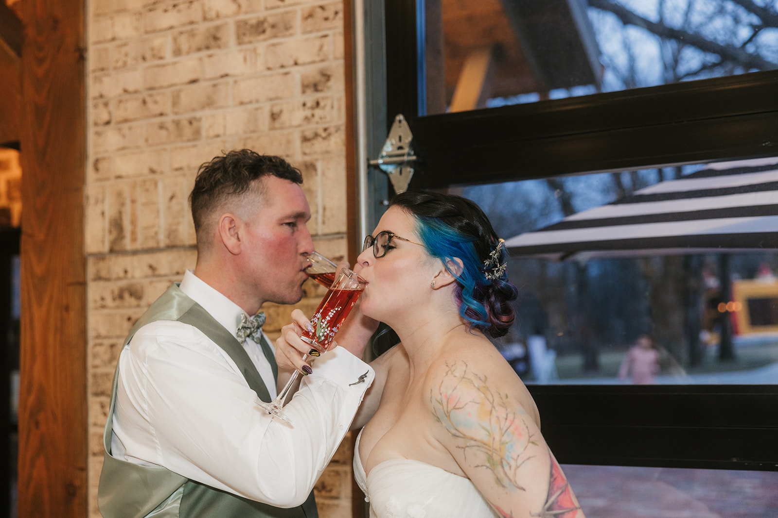 A bride and groom smiling as they cut their wedding cake together at a decorated indoor venue for their wedding at Discoveryland Ranch