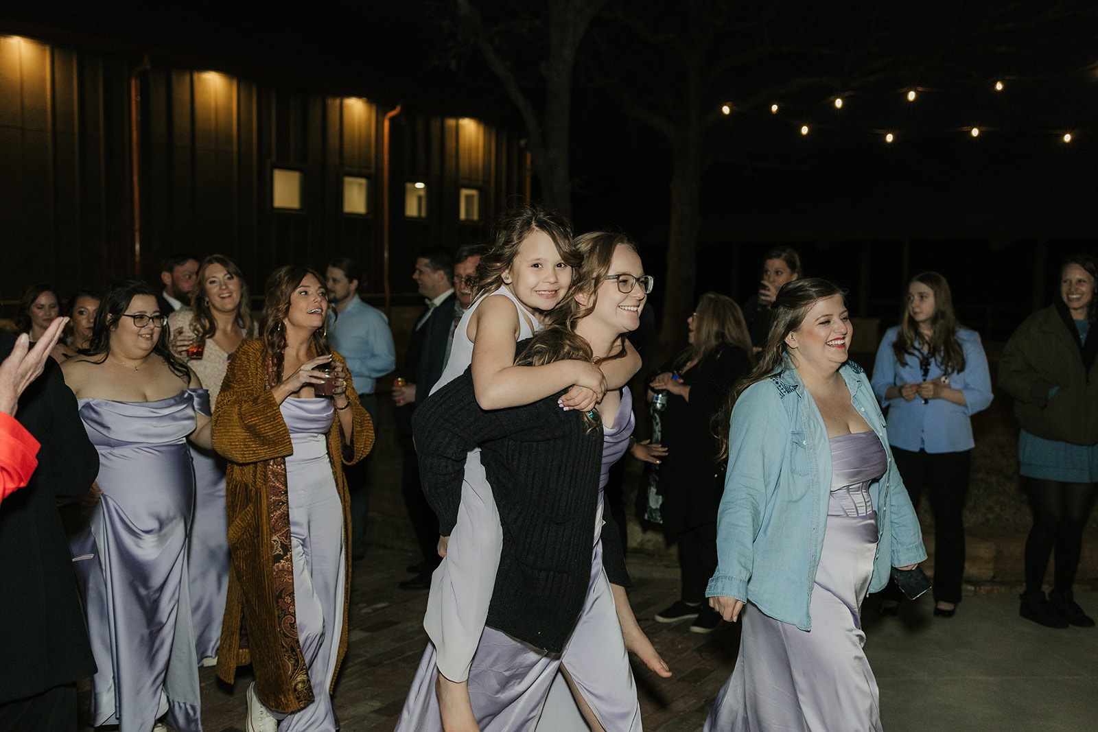 people dance on the dance floor outdoors at a wedding