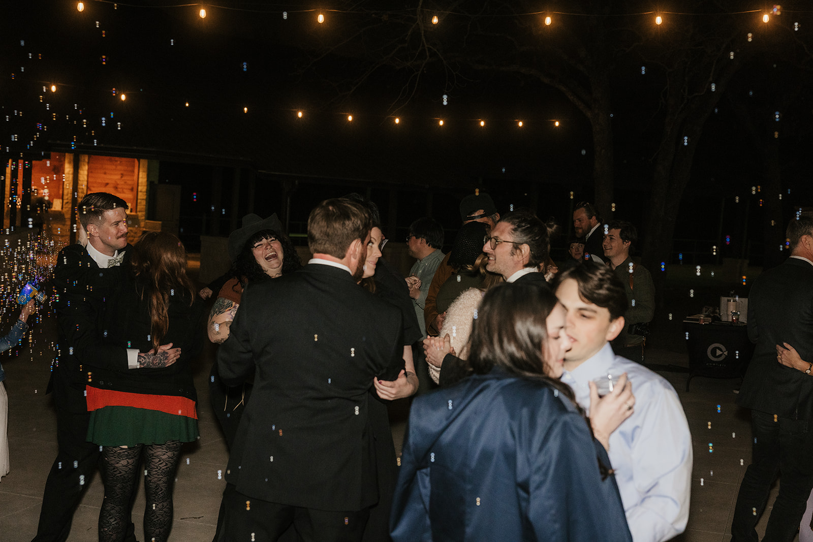 people dance on the dance floor outdoors at a wedding