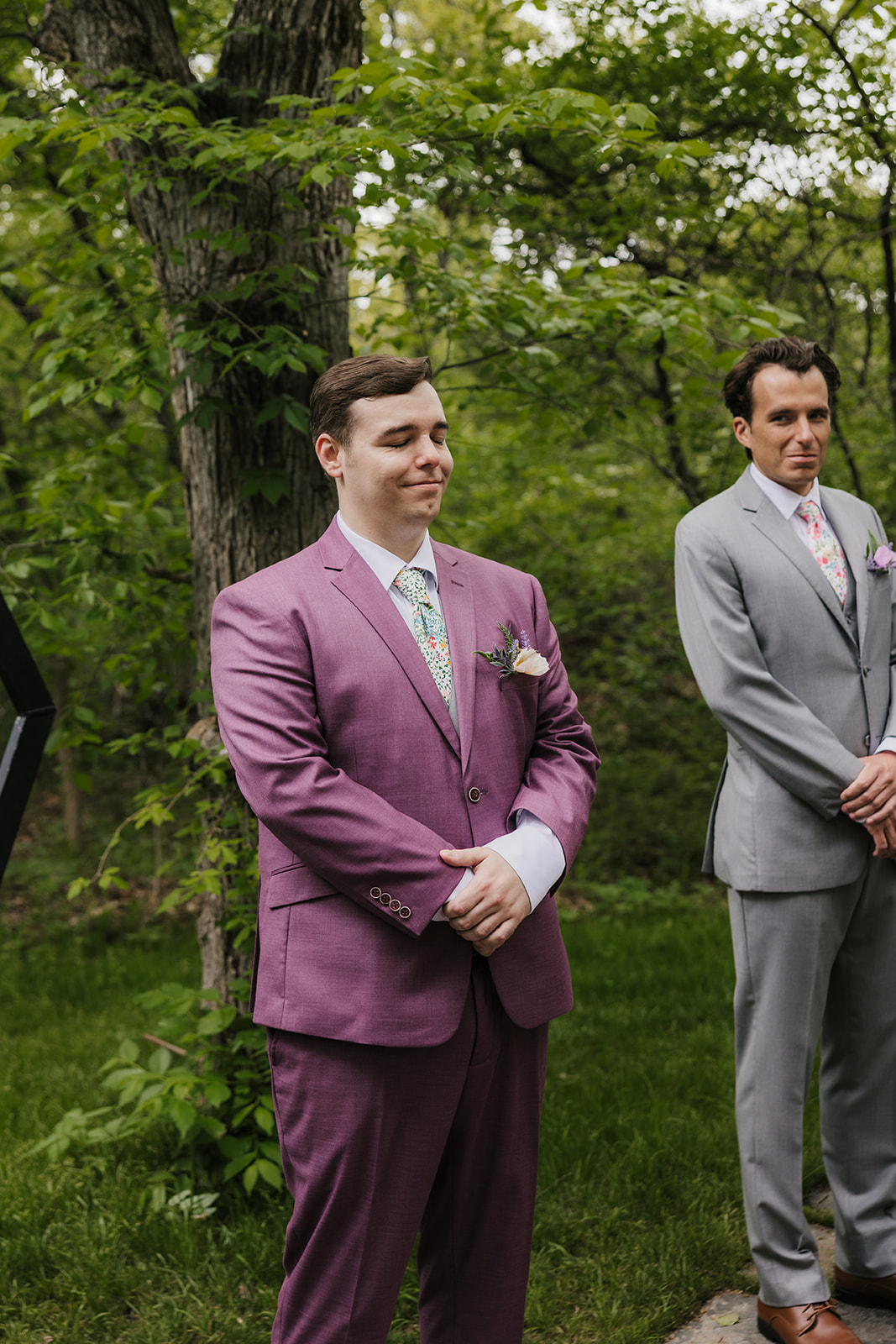 A couple under a geometric arch draped with white fabric during an outdoor wedding ceremony as guests watch and applaud for a wedding at Merrick Hollow Wedding