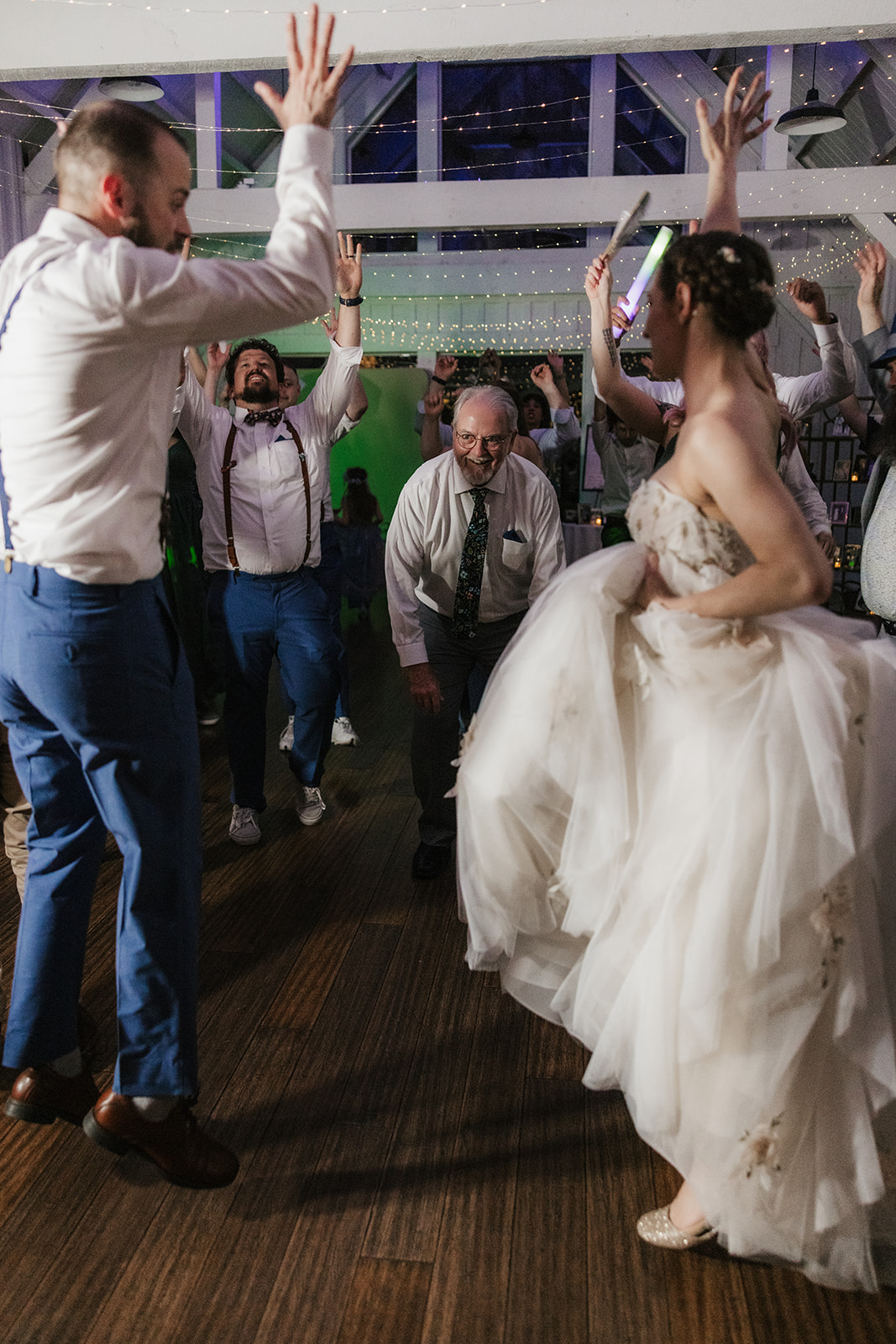 people dancing on the dance floor for a fun wedding at spain ranch