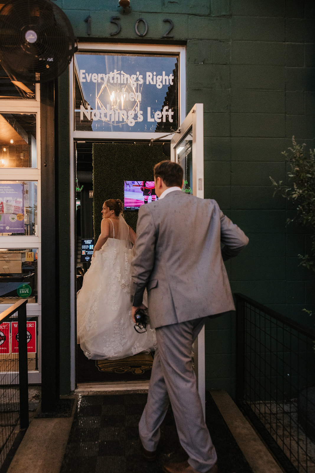 A bride and groom share a dance at their wedding reception indoors, with guests and decorations visible in the background at a Camp Loughridge Wedding