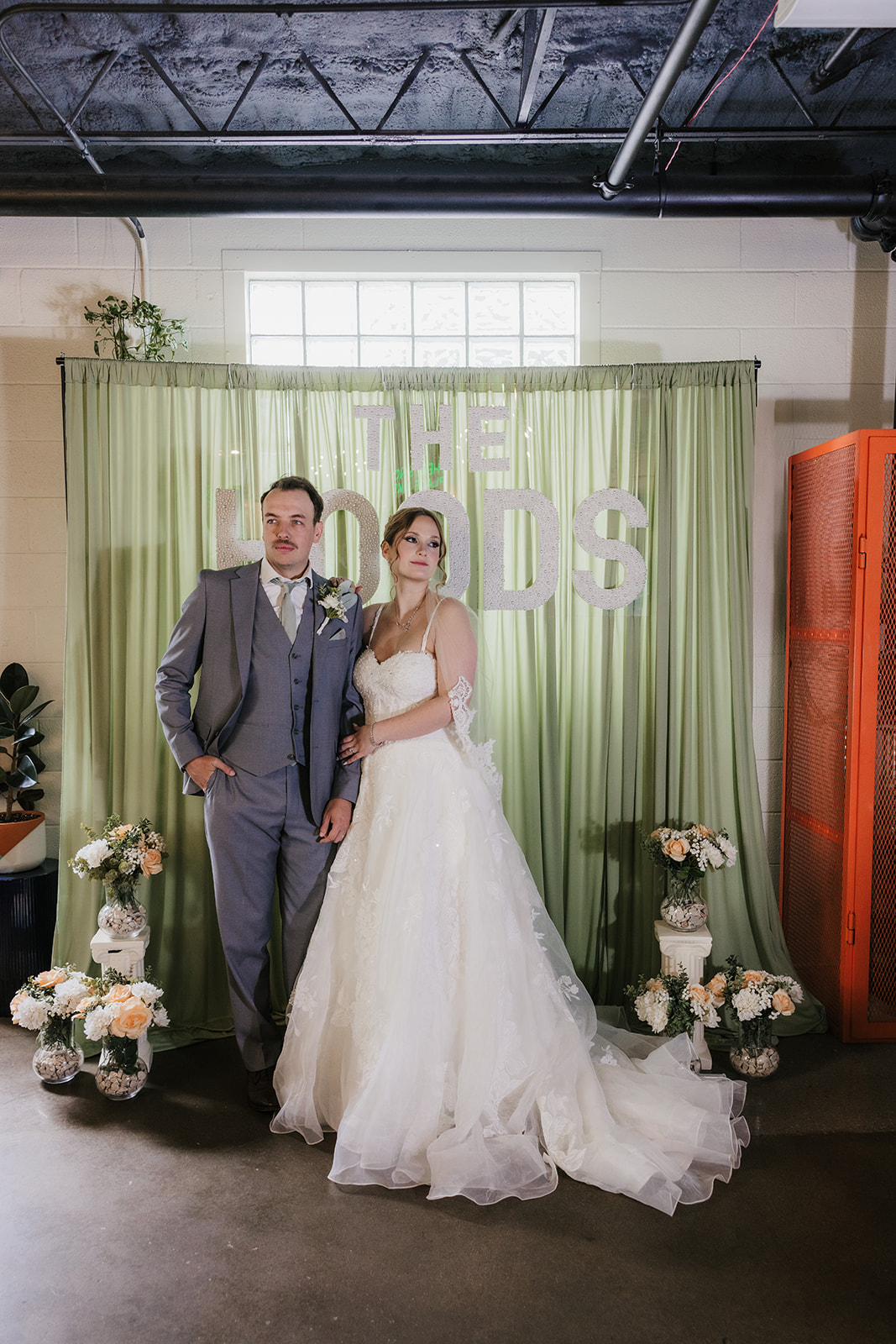 A bride and groom share a dance at their wedding reception indoors, with guests and decorations visible in the background at a Camp Loughridge Wedding