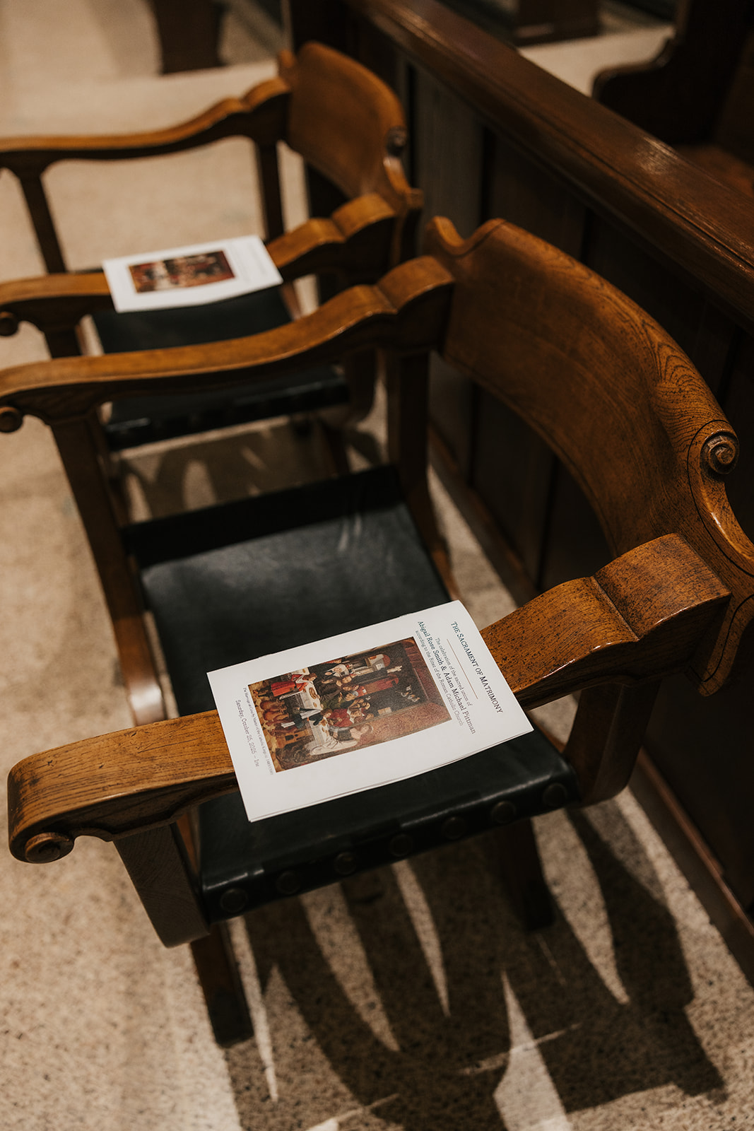 White shoes, a pearl necklace, a rosary, a ring in a blue box, a small perfume bottle, and a pin arranged on an upholstered chair.