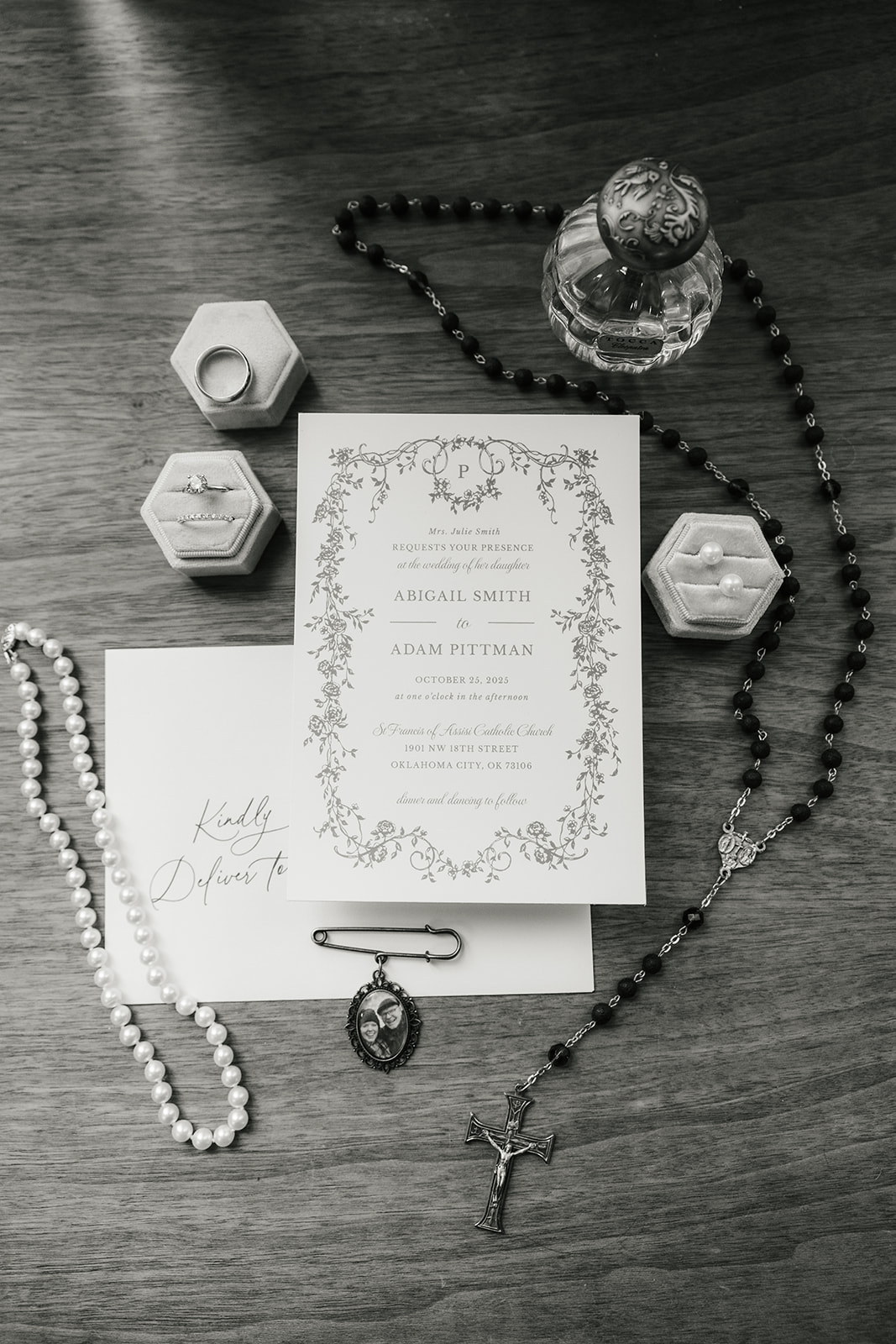 White shoes, a pearl necklace, a rosary, a ring in a blue box, a small perfume bottle, and a pin arranged on an upholstered chair.