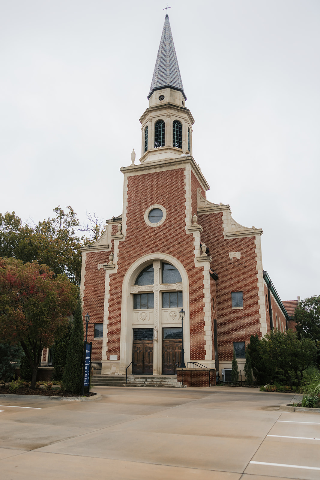 White shoes, a pearl necklace, a rosary, a ring in a blue box, a small perfume bottle, and a pin arranged on an upholstered chair.