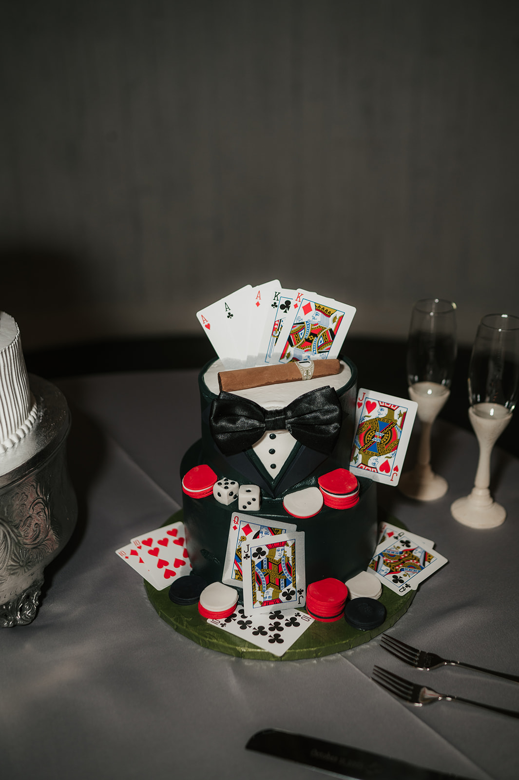 A bride and groom wearing cowboy hats feed each other cake beside a decorated wedding cake and glasses of champagne.