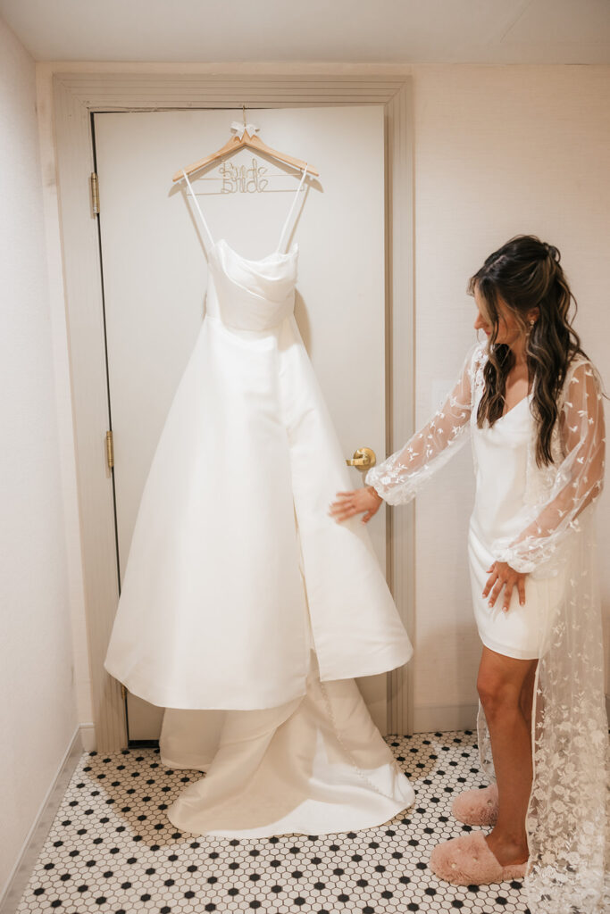 portrait of the bride next to her wedding dress