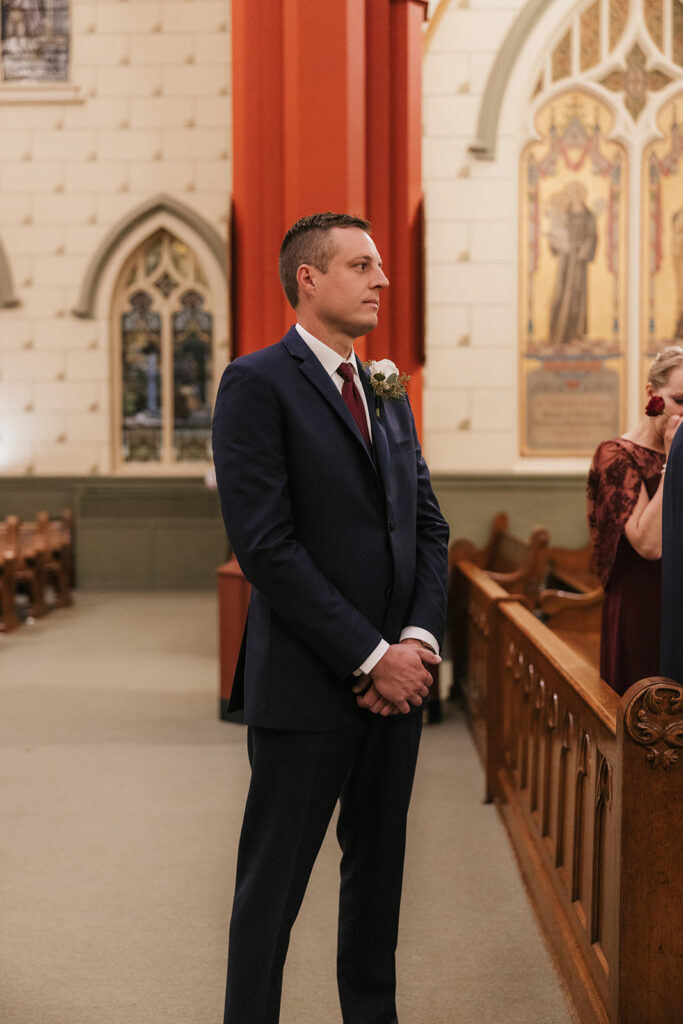 groom watching the bride  walk down the aisle