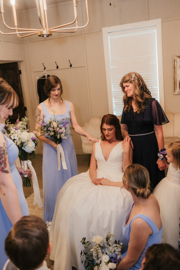 cute picture of the bridesmaids praying over the bride