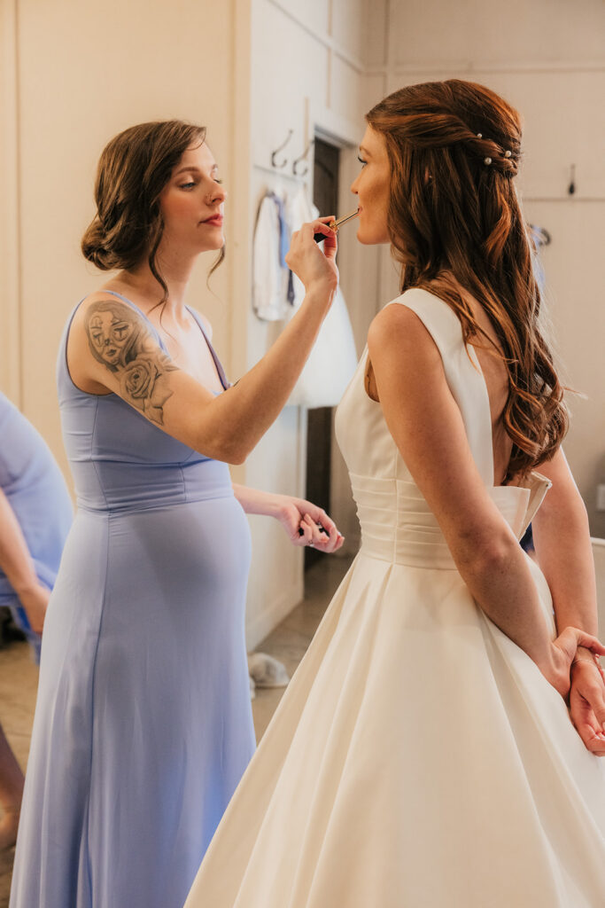 bride getting her makeup done before the ceremony