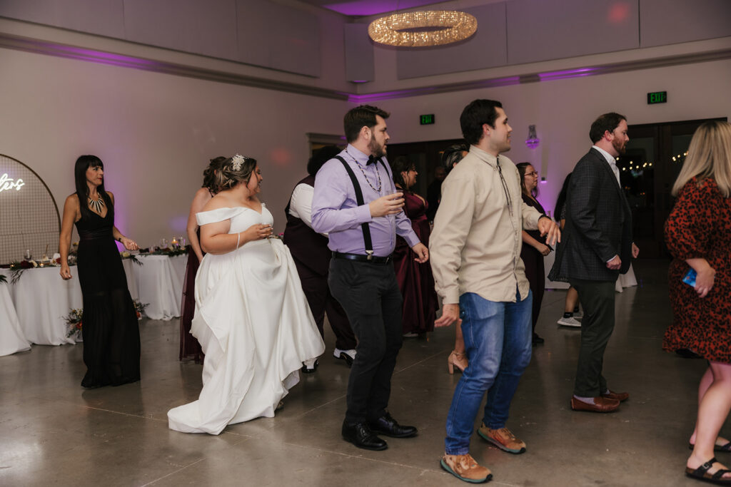 newlyweds and their wedding guests dancing at the wedding reception