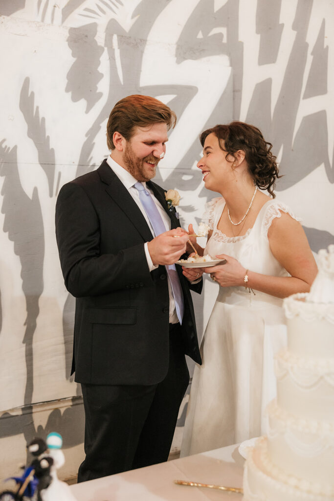 portrait of the newlyweds trying their wedding cake