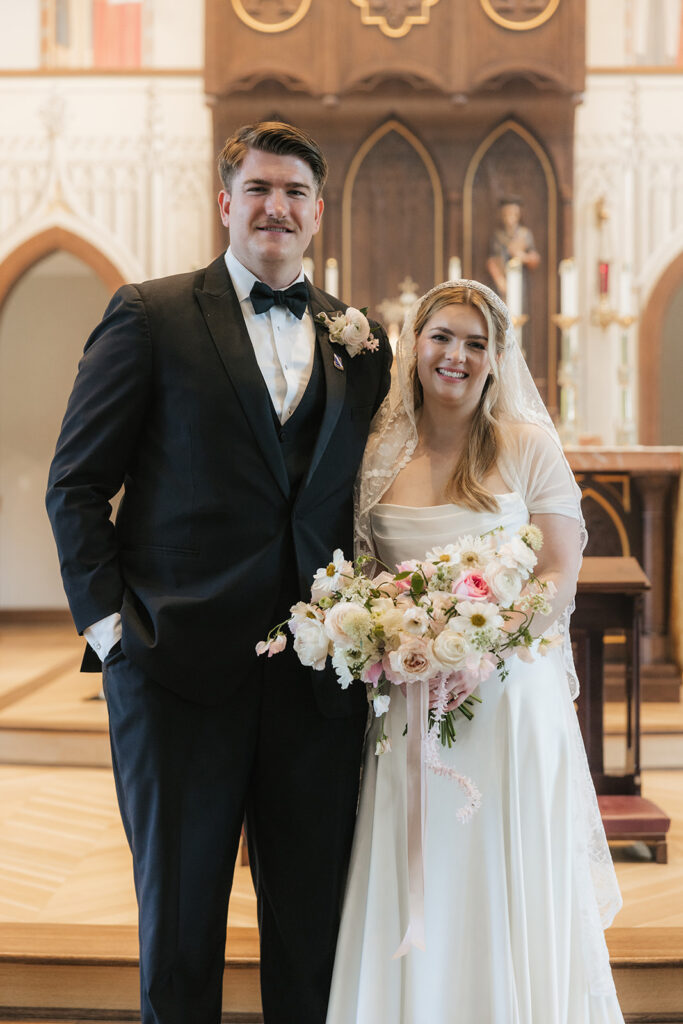 cute picture of the newlyweds smiling at the camera during their photoshoot