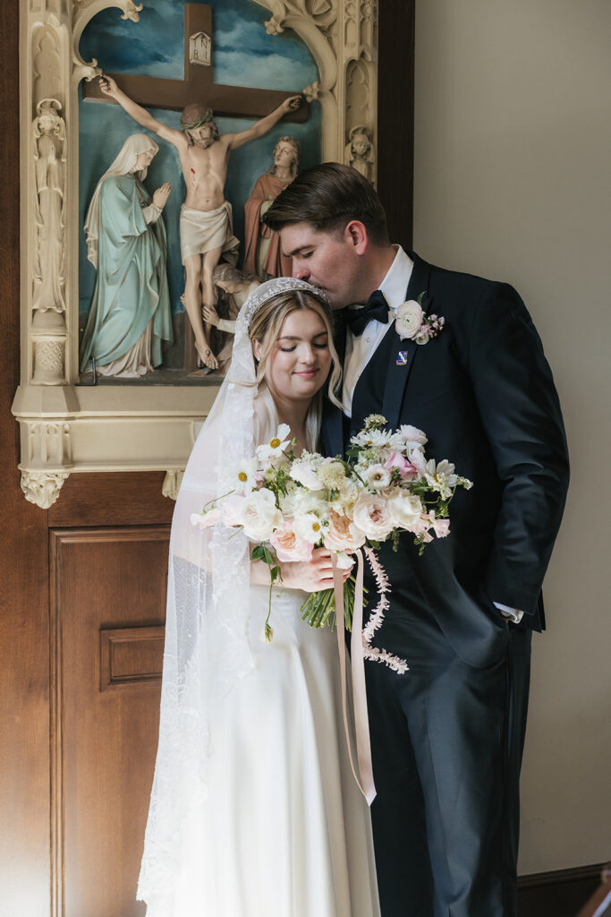 groom kissing the bride on the forehead