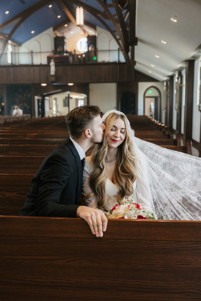 groom kissing the bride on the cheek