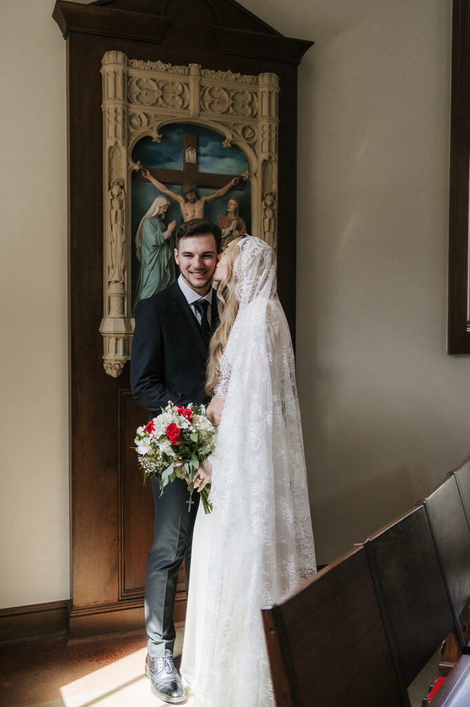 cute picture of the bride kissing the groom on the cheek
