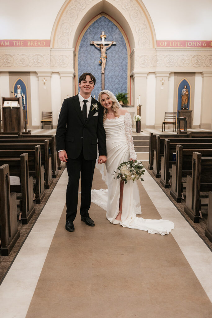 bride and groom smiling at the camera during their photoshoot