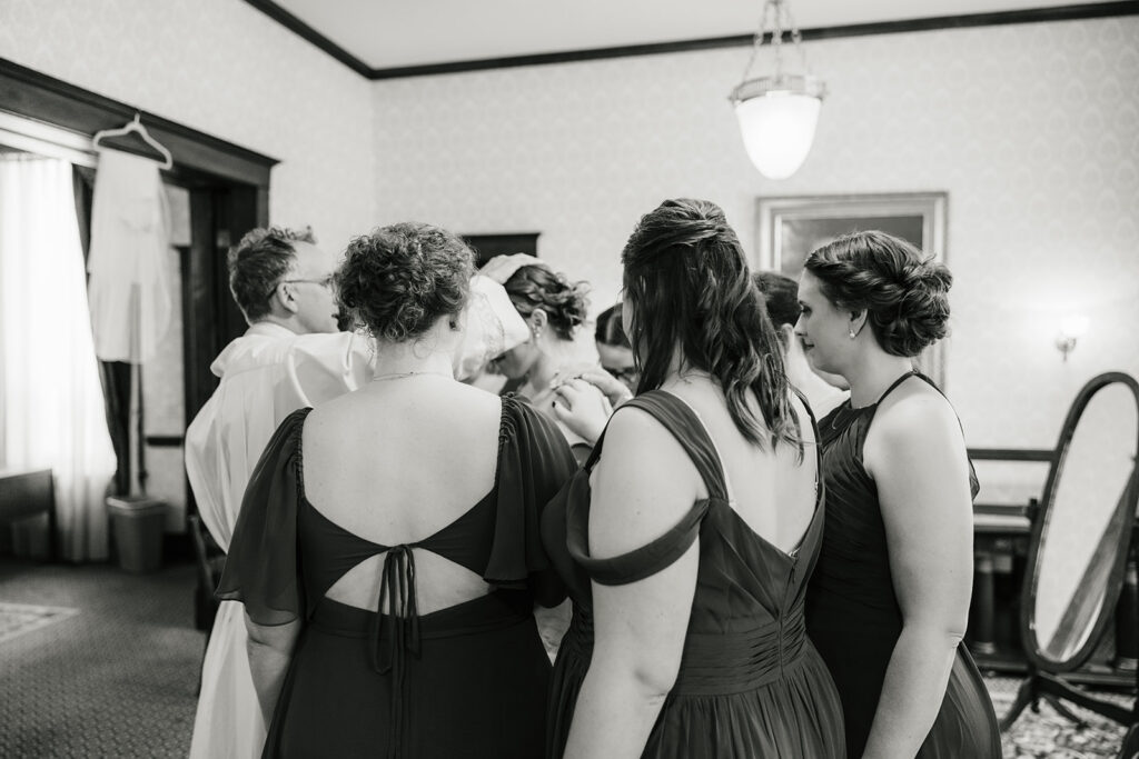 bridesmaids praying over the bride