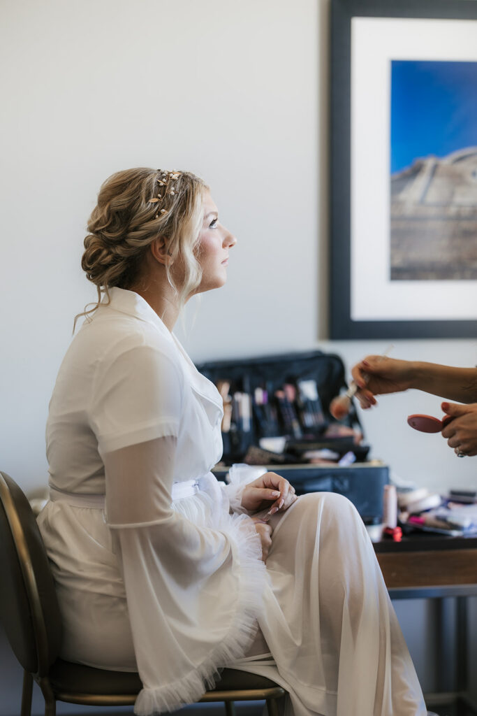 bride getting her makeup done for her ceremony