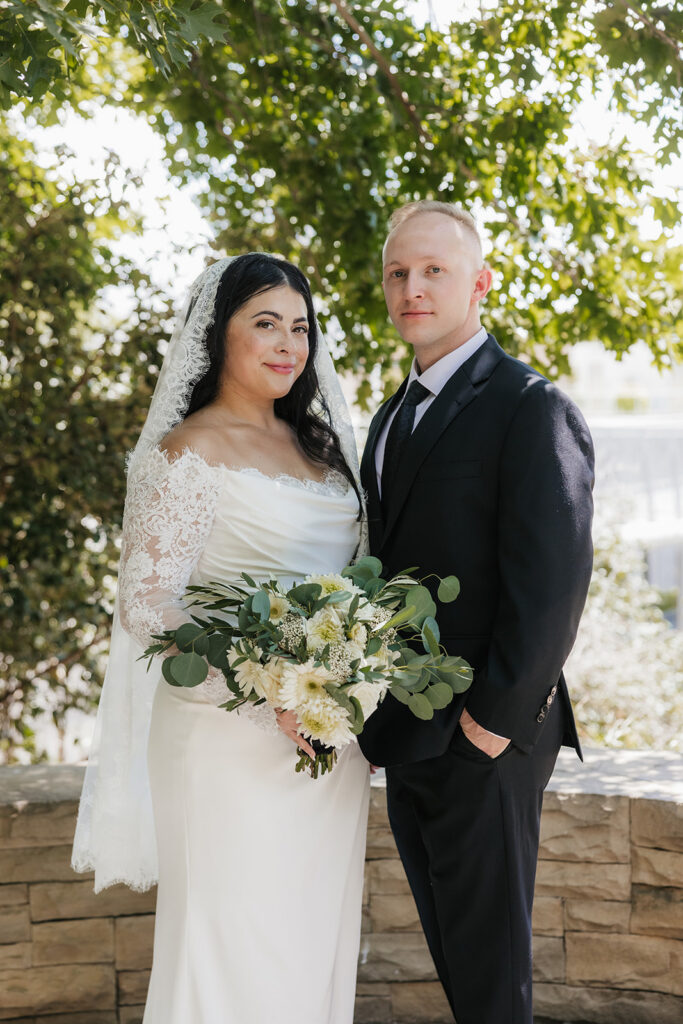 newlyweds smiling at the camera during their photoshoot