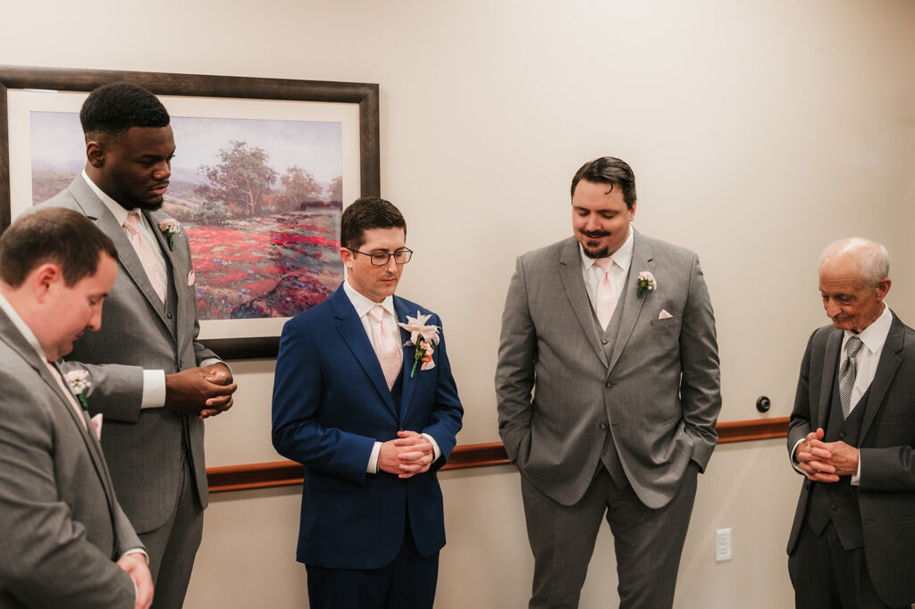 Picture of the groom and groomsmen praying before the ceremony