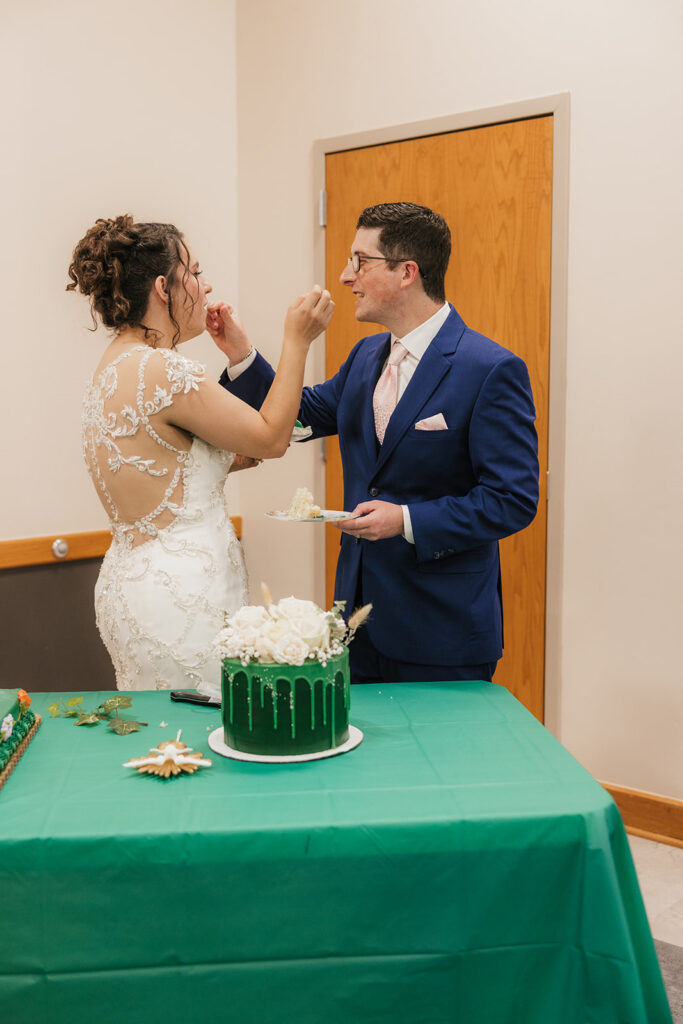 newlyweds trying their wedding cake